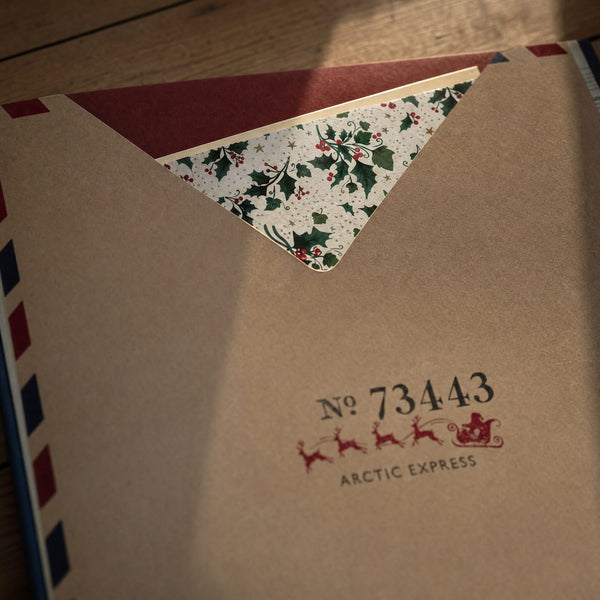 Letters from the North Pole - The holly-lined letter tucked into the Arctic Express pocket page of Letters from the North Pole