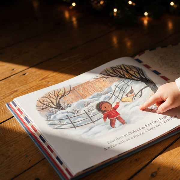 Letters from the North Pole - The robin illustration page inside Letters from the North Pole, a small hand resting on the page
