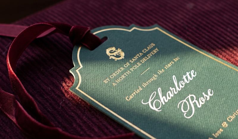 A green personalised gift tag reading Charlotte Rose on the corduroy trunk lid